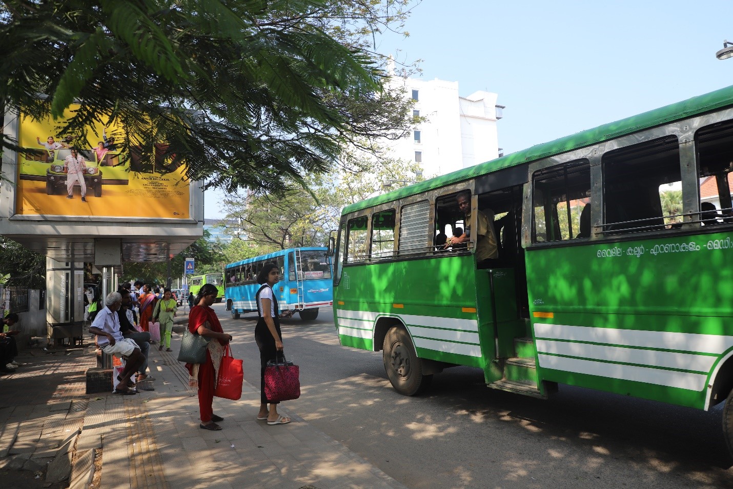 A group of people waiting for a bus  Description automatically generated